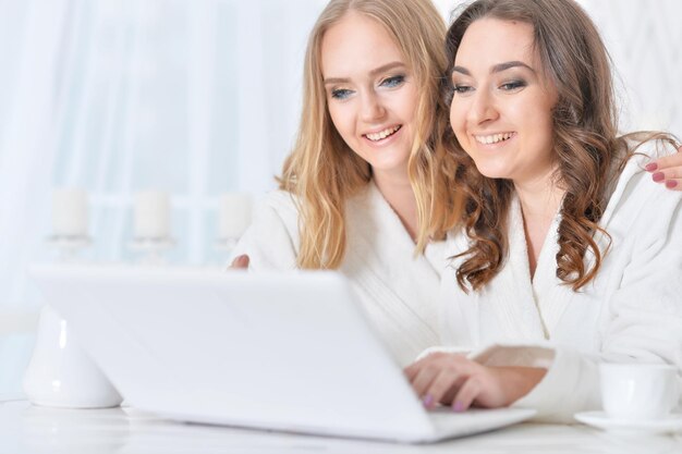 Portrait of two young girls with laptop