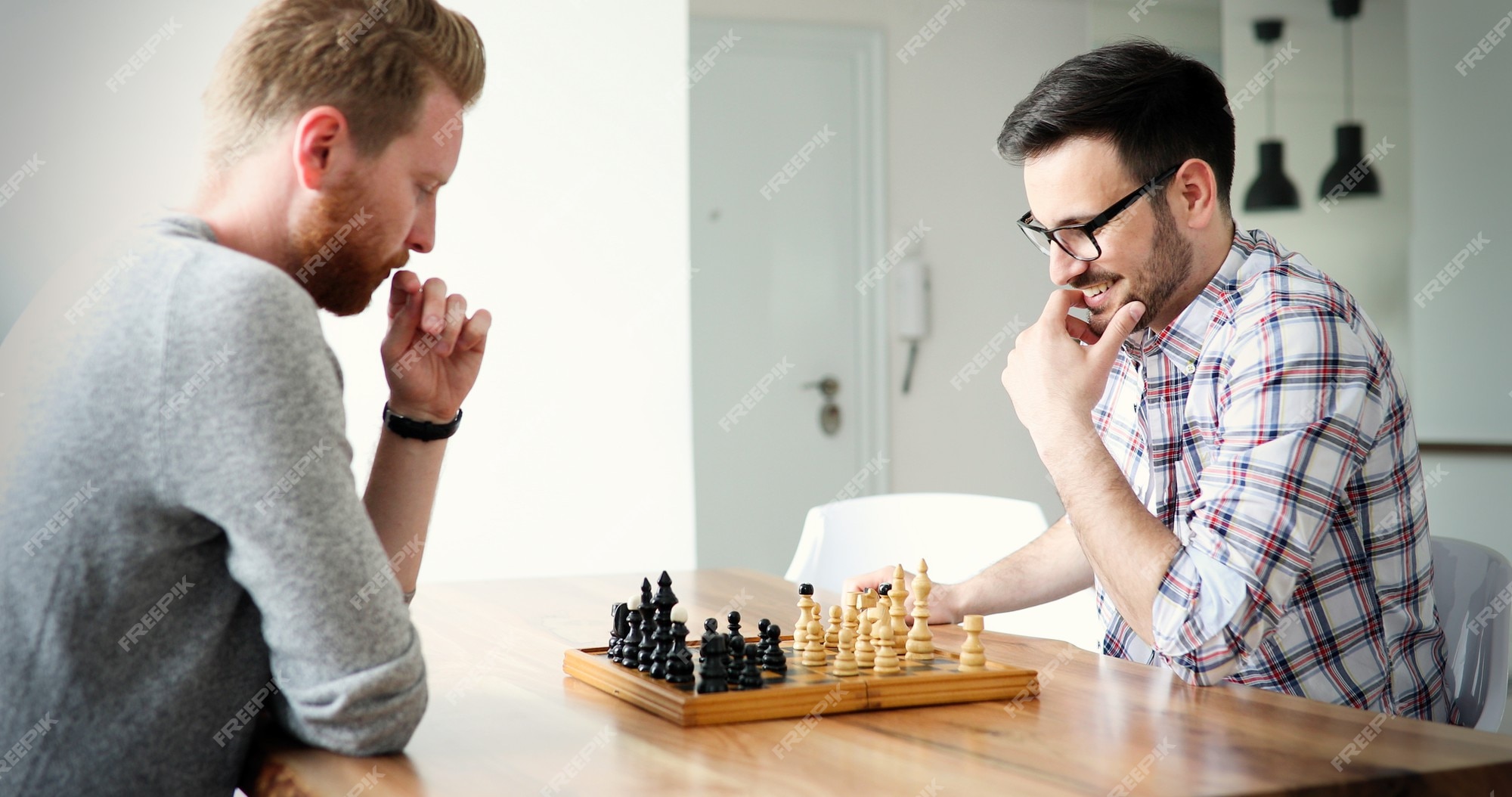 Premium Photo  Two young man are playing chess