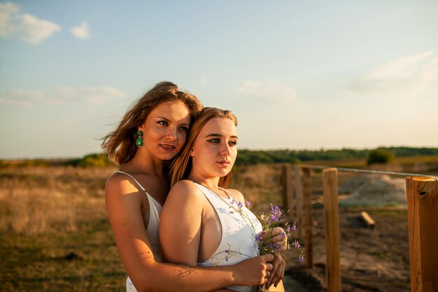 Photo portrait of two young women on field against sky