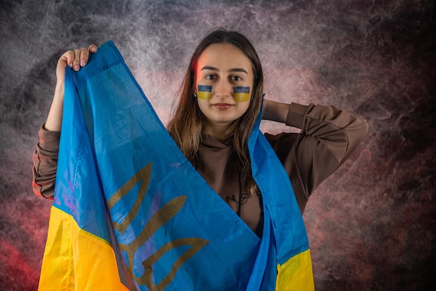 Portrait of a Ukrainian woman with a flag on the cheek sadness longing for hope of peace