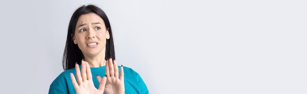 Portrait of uncomfortable pretty brunette, raising palms in stop gesture. That is enough, thanks.