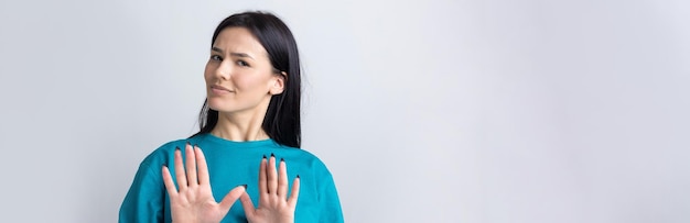 Portrait of uncomfortable pretty brunette raising palms in stop gesture That is enough thanks