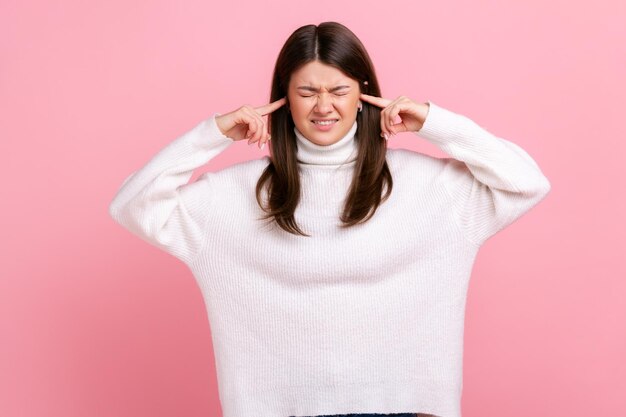 불행한 아름다운 여성이 서서 손으로 귀를 막고 듣고 싶지 않은 초상화