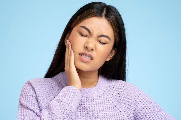 Portrait of unhealthy ill woman felling toothache after drinking hot or cold beverage