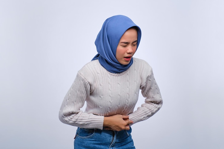 Portrait of unhealthy young Asian woman having stomach ache menstrual period cramps isolated on white background