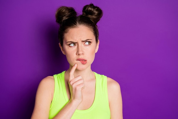 Портрет неуверенной девушки, кусающей губы, выглядит Copyspace Think носить майку, изолированную на фиолетовом цветном фоне
