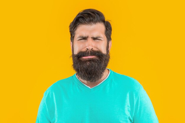 Portrait of upset bearded guy in studio portrait of bearded guy on background