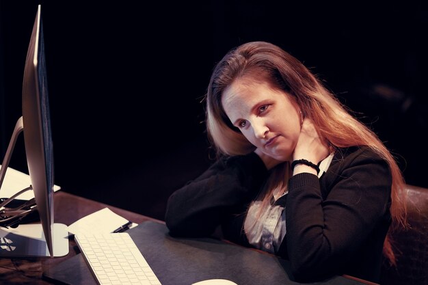 Portrait of upset office worker, manager woman sitting in front of the monitor of computer.