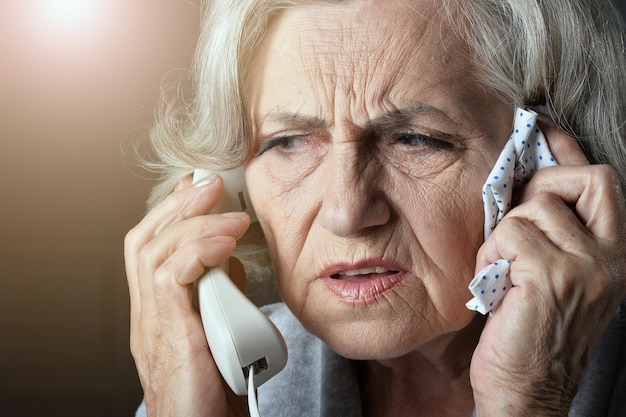 Портрет расстроенной пожилой женщины, звонящей врачу
