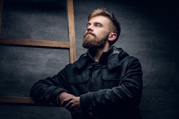 Portrait of urban bearded male dressed in a black stylish winter jacket.