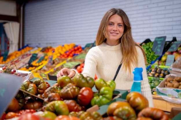 Портрет вегетарианки, покупающей овощи и зелень в продуктовом магазине