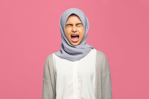 Portrait of very angry young Asian woman with mouth opened