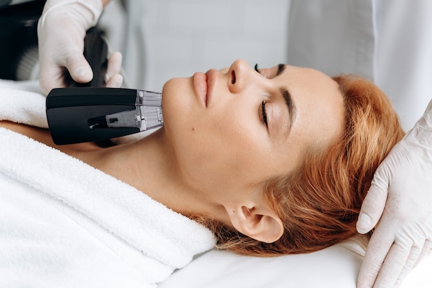 Portrait view of the female face. Woman laying at the couch with closed eyes in professional beauty clinic during laser hair removal