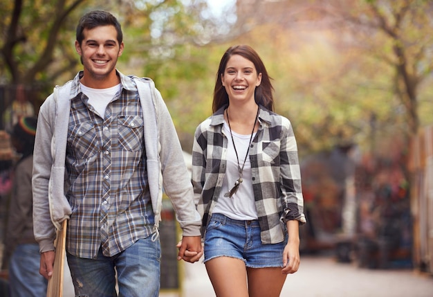 Foto portrait passeggiata e coppia che si tengono per mano sorridendo e felici nel viaggio di relax viaggio mattutino o appuntamento di fine settimana legame di relazione amante e giovani romantici viaggiano per strada strada o marciapiede