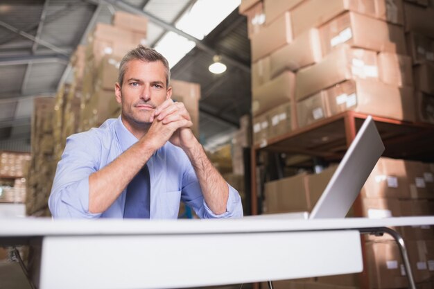 Portrait of warehouse manager with laptop