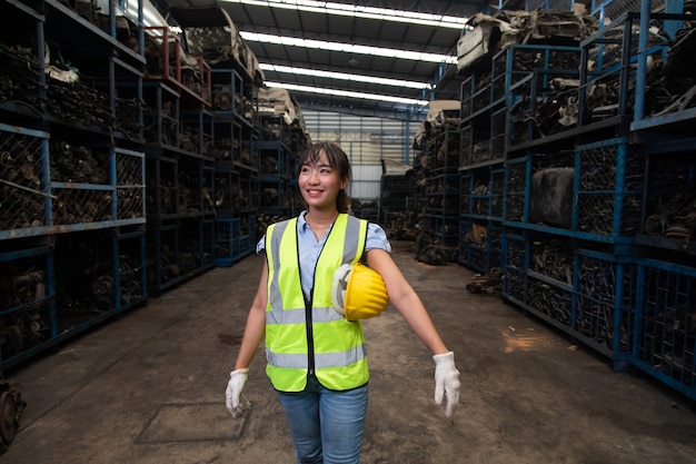 Portrait warehouse managers or worker asian woman working  at large distribution warehouse of old car part.