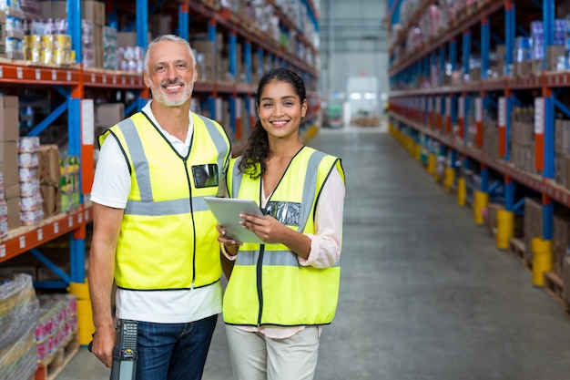 Portrait of warehouse workers standing with digital tablet