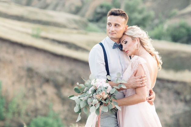 Portrait of wedding couple on the nature in summer day. the bride and groom hugging at the wedding.