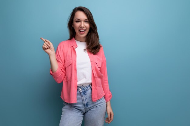 Portrait of a wellgroomed european young blackhaired woman with shoulderlength hair in a pink shirt