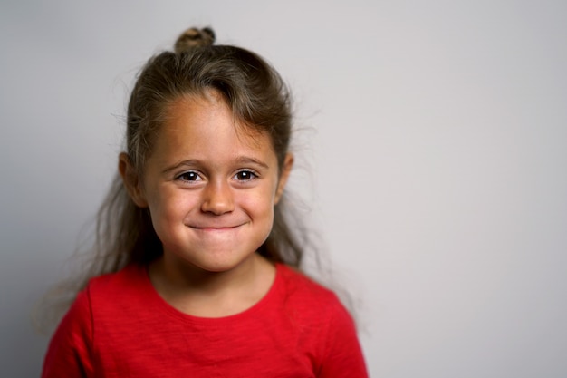 Ritratto su sfondo bianco di una ragazza italiana di 4 anni guardando lateralmente