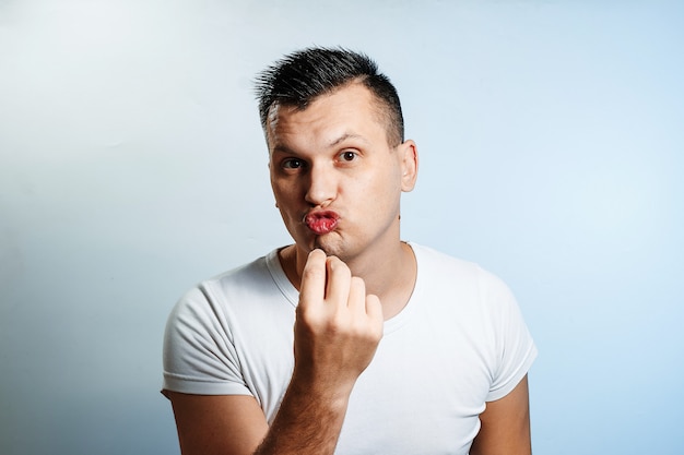 Portrait of a white man on light , gesture two fingers near the eyes. 