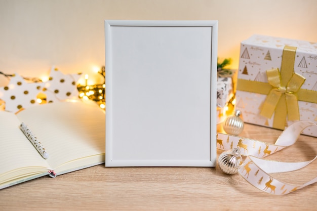 クリスマスプレゼント、bokenライトと肖像画の白い額縁のモックアップ。高品質の写真