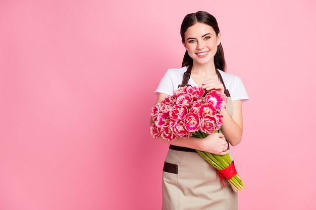 Portrait of winsome girl retail manager holding romantic spring flowers