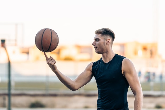 Portrait with copy space of a basketball player juggling a ball on an outdoor court