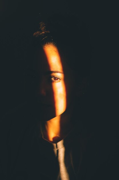 Portrait of woman against black background