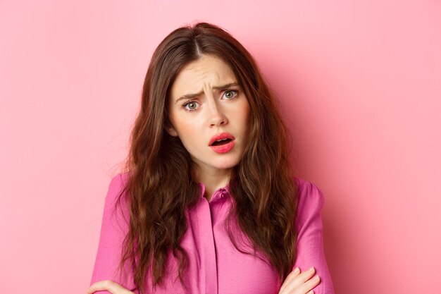 Portrait of woman against pink background