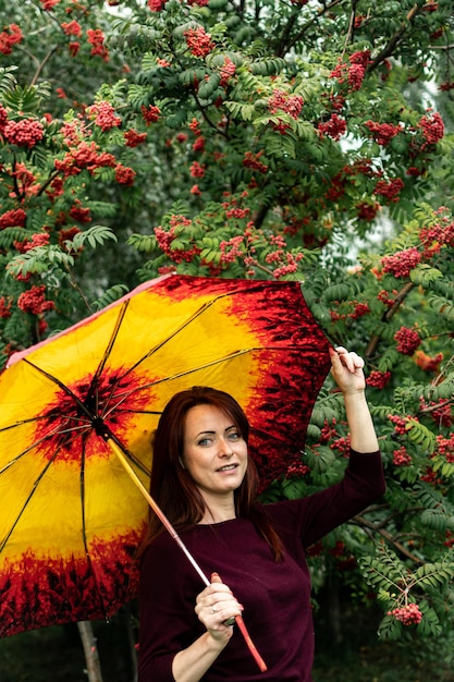 portrait of a woman in an autumn park rowan trees with berries beautiful portrait