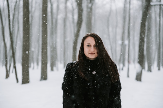 Portrait of a woman on the background of a snowy forest