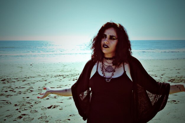 Portrait of woman at beach against clear sky