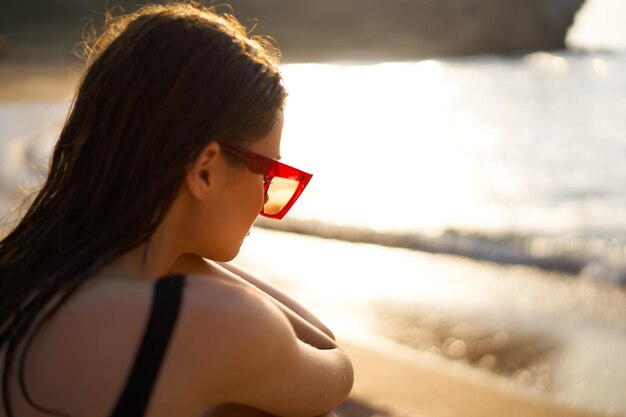 Foto ritratto di una donna sulla spiaggia durante il tramonto