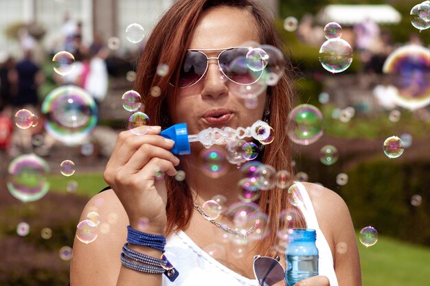 Foto ritratto di una donna che soffia bolle