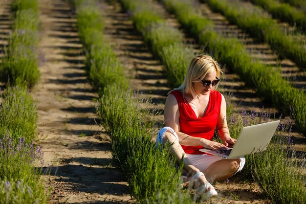 Portrait of a woman buying online or booking hotel with a laptop and credit card on the beach in vacations. e commerce concept