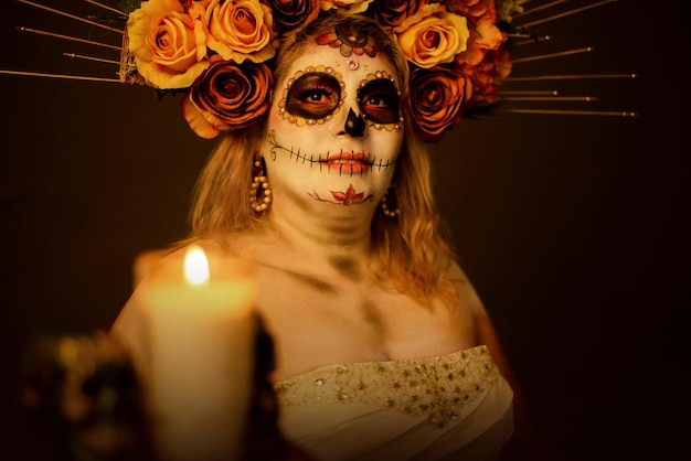 Ritratto di una donna in trucco catrina che indossa un abito da sposa candela e teschio sfocati in primo piano