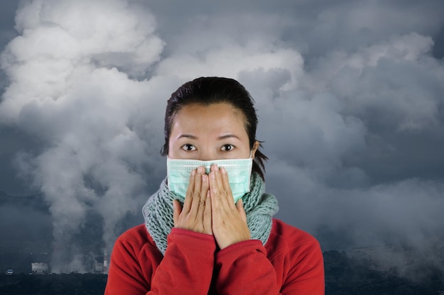 Portrait of woman covering face against sky