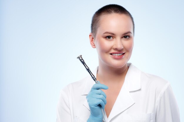 Portrait of a woman dermatologist holding cosmetic device attachment