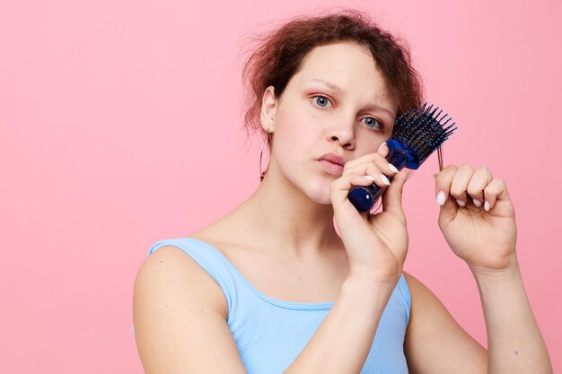 Portrait of a woman dislike comb on hair emotion pink color
background unaltered