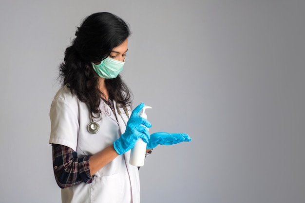 Portrait of woman doctor showing a bottle of sanitizing gel for hands cleaning.