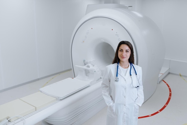 Portrait of a woman doctor in a white coat who stands against the background of an MRI in the hospital