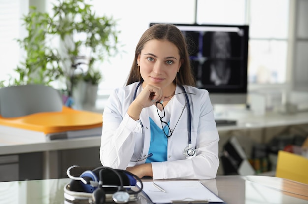 Portrait of woman doctor with glasses in her hands in clinic office