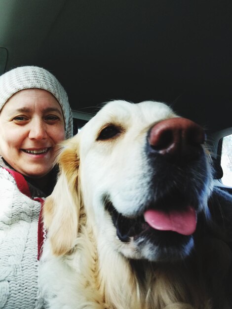 Photo portrait of woman dog sitting in car