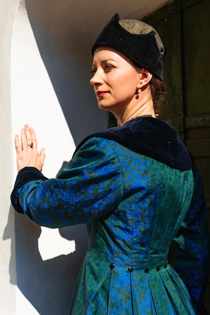 Portrait of woman dressed in blue historical Baroque clothes with old fashion hairstyle outdoors