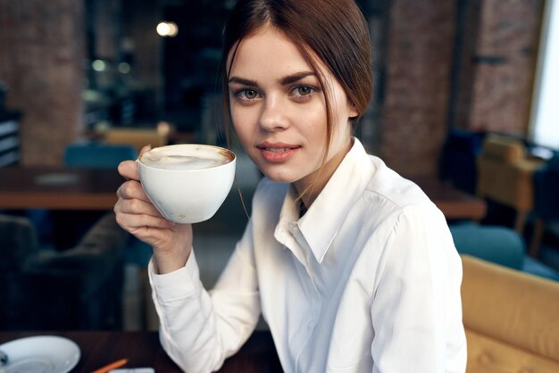 Photo portrait of woman drinking coffee in cafe