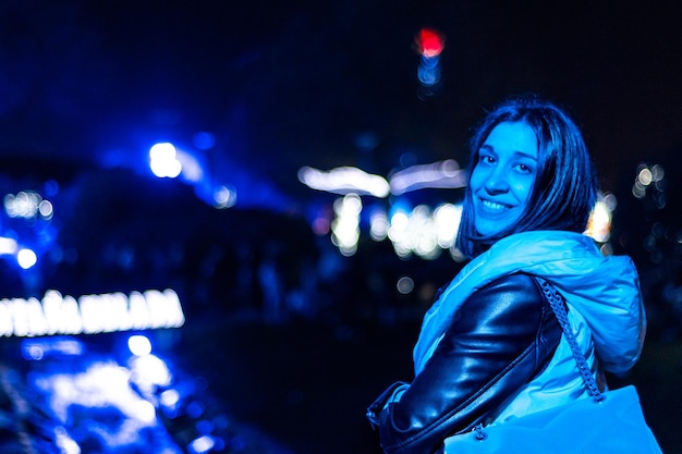Photo portrait of a woman at a fair with a smiling face looking at camera at night