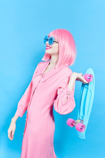 Portrait of a woman fashion blue glasses skateboard studio model unaltered high quality photo