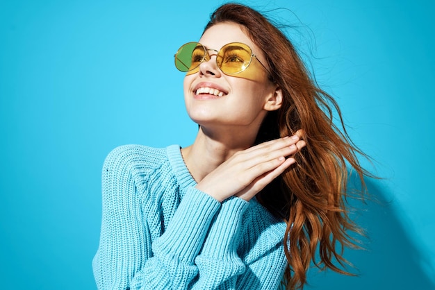 Portrait of a woman in fashionable glasses blue background High quality photo