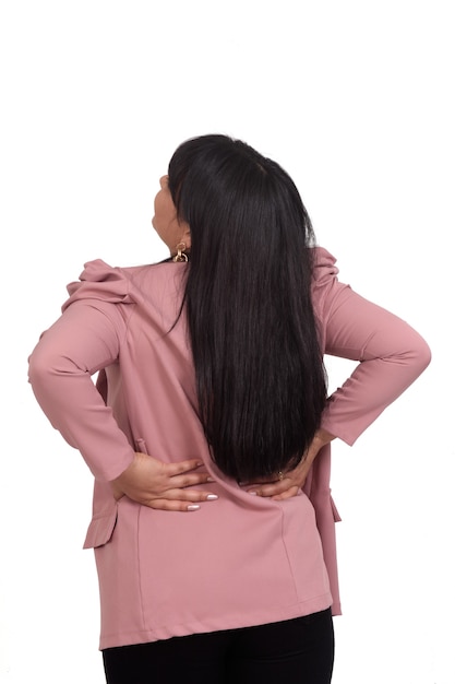 Portrait of a woman from behind with pain in her back on white wall